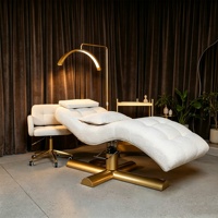 Table de massage en métal réglable en hauteur avec design incurvé en forme de S de luxe pour salon de beauté avec revêtement en cuir synthétique