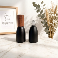 Vente en gros de flacons à bille en verre noir mat opaque de 12 ml, flacons de luxe pour huiles parfumées avec bille en acier et couvercle en bois foncé naturel