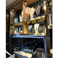 Boutique de bijoux de style industriel, aménagement complet sur mesure, îlot central, vitrine, armoires murales avec escalier en colimaçon