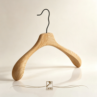 Design non conventionnel utilisé pour la présentation de vêtements avec des cintres en bois massif de couleur bois naturel