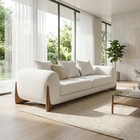 Canapé élégant en tissu blanc avec pieds en bois, canapé moderne et spacieux pour salon lumineux avec grandes fenêtres