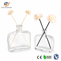 Diffuseur de parfum en verre transparent avec silhouette moderne et élégante, et bâtonnets décoratifs pour un style d'intérieur contemporain