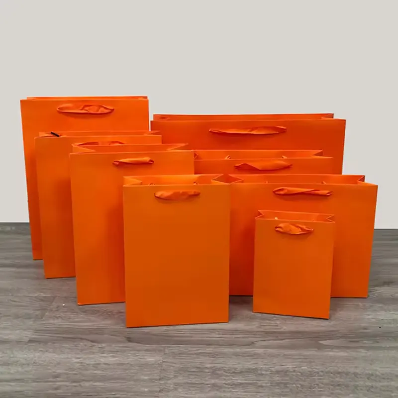 22*10*18cm naranja ropa al por mayor en Stock bolsa de papel Kraft con asa precio barato bolsa de compras para llevar aceptar impresión personalizada