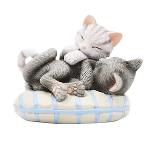 灰色和黑色的猫在圆形的蓝色和灰色条纹枕头上休息，形状为爱情雕像