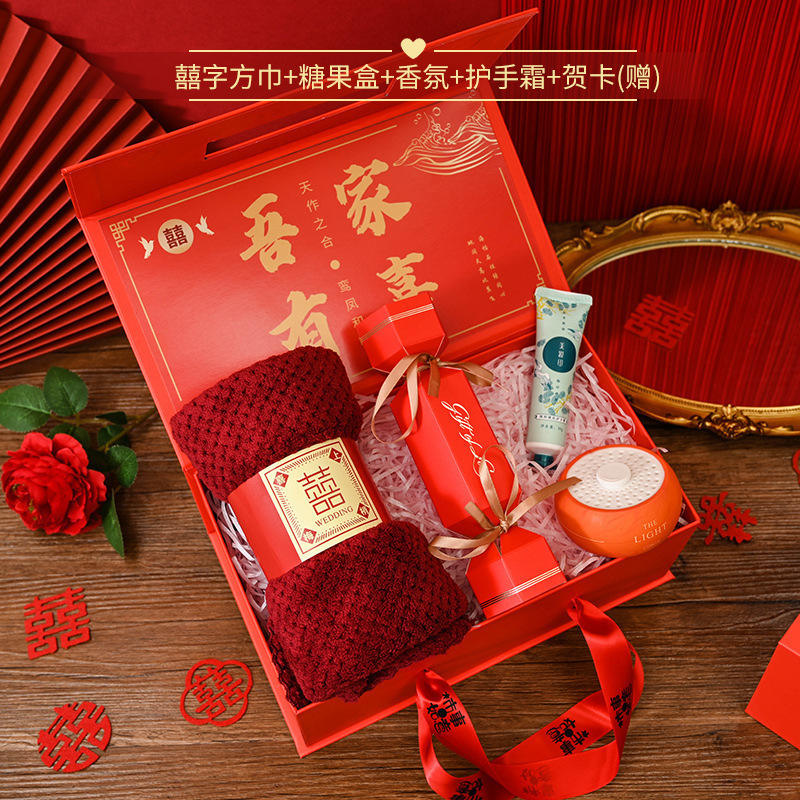Ensemble de quatre pièces comprenant un mouchoir carré orné du caractère «囍 » (double bonheur), une boîte de bonbons et une crème parfumée pour les mains, le tout présentée dans une boîte rouge en forme de kaki symbolisant la bonne fortune.