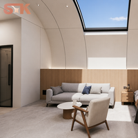 Capsule habitable avec chambre, salon, salle de bain, fenêtre incurvée en verre, lucarne, coque blanche, cadre foncé, maison capsule préfabriquée