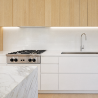 Meubles de cuisine modernes blancs à panneaux plats avec grand îlot, appareils électroménagers intégrés et design minimaliste en open space