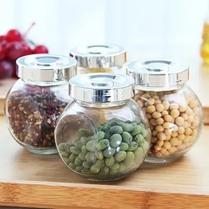 Venta al por mayor de alimentos de vidrio tarro de almacenamiento pequeña y mediana capacidad transparente plana tambor forma níspero botella de embalaje