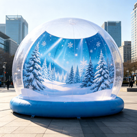 Globe de neige gonflable géant transparent pour Noël, avec fond personnalisé et base rouge, idéal pour l'affichage en centre commercial, la location pour événements et la décoration de fêtes