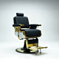 Fauteuil de barbier de luxe rétro avec cadre en métal plaqué or noir, coutures verticales, inclinable hydrauliquement