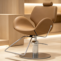 Chaise de barbier élégante au design incurvé, confortable, rembourrée, réglable en hauteur, avec base chromée pour salon de coiffure