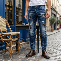 Pantalon slim en denim bleu vintage pour homme, style streetwear automne, avec patch logo au dos, détails déchirés et tissu froissé