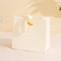 Sac cadeau artisanal en papier kraft beige crème recyclé personnalisé Sac à provisions de luxe ivoire avec bougie et poignée torsadée avec logo personnalisé