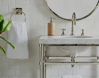Meuble-lavabo haut de gamme pour suites de luxe, avec plateau en marbre de Carrare, pieds en acier inoxydable chromé poli et finition laiton doré brillant