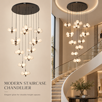 Lustre d'escalier moderne de luxe avec grappes de verre transparent laiteux en forme de pétale, centres en métal foncé, éclat doux et chaleureux, design intérieur élégant
