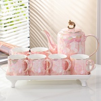 Elegante tetera de cerámica y 6 tazas de té con un mango de color dorado y una tapa con un acabado brillante iridiscente