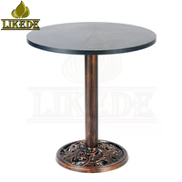 Table ronde en fonte avec finition cuivre vintage, base sur pied robuste avec plateau en mélamine pour café, bar, restaurant