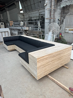 Canapé d'angle en marbre sur mesure, design moderne et écologique, structure beige en pierre, coussins en cuir noir, idéal pour appartement de luxe