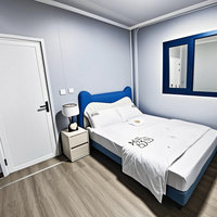 Maison conteneur préfabriquée à ossature acier, cabine modulaire avec panneaux imitation bois et fenêtre à battant, espace habitable
