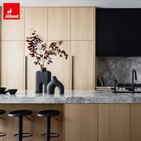 Projet Villa Alland : Armoires de cuisine modulaires en contreplaqué sur mesure, finition grain de bois, avec îlot et table extensible