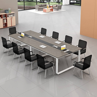Table de réunion contemporaine avec surface spacieuse, accès intégré aux appareils et base blanche élégante