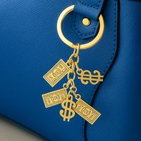 Porte-clés multi-breloques en or noble avec signe dollar et breloque sac de richesse pour les amateurs d'argent