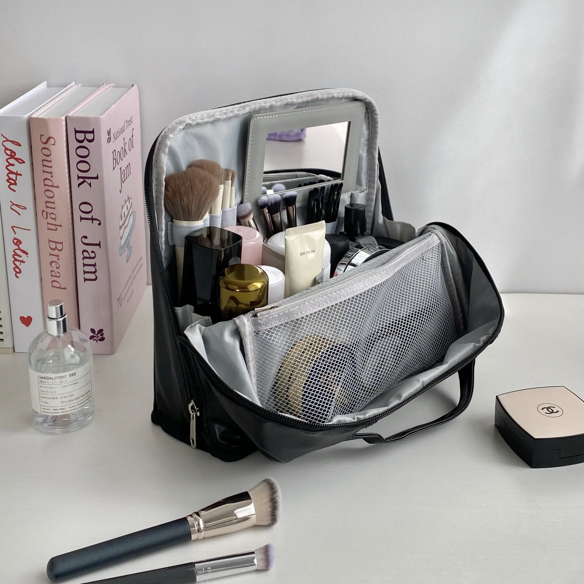 Trousse de toilette noire avec miroir intégré.