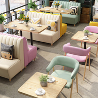 Ensemble de salle à manger avec fauteuils courbes aux couleurs pastel et table en bois clair, banquette et chaises pour restaurant de restauration rapide (hamburger)