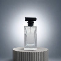 Flacon de parfum élégant en verre transparent rectangulaire avec bouchon noir facetté et atomiseur à fine brume pour la vente au détail