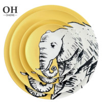 Service de table en porcelaine fine série animale, décor jaune mat, comprenant tasses et soucoupes, assiette de présentation en céramique motif éléphant