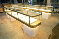 Présentoir à bijoux moderne sur mesure avec cadre doré, éclairage LED personnalisé et vitrine ronde en verre