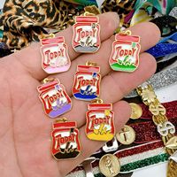 Liontin Makanan Kaleng Enamel Martin dan Popes. Liontin Enamel Berlapis Emas dengan Tema Minuman Venezuela