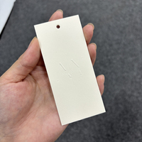 Étiquettes volantes personnalisées en carton ivoire/crème pour vêtements, avec impression de logo en feuille, finition mate blanc cassé pour produits