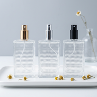 Flacon de parfum en verre transparent carré ALKA Luxury 100 ml, imprimé en sérigraphie, avec vaporisateur en aluminium et diffuseur à bâtonnets.