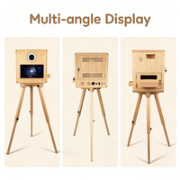 La nouvelle cabine photo mobile en chêne présente une coque en bois, équipée d'une imprimante à transfert thermique et d'un appareil photo reflex numérique.