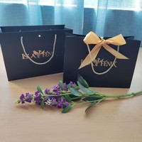 Sac cadeau en papier noir de luxe avec logo personnalisé en feuille d'or et poignée en ruban, emballage boutique pour le shopping