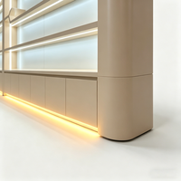 Mur de présentation de luxe moderne pour les produits de beauté |   Étagères courbes sur mesure et éclairage LED |   Intérieur d'un magasin de cosmétiques haut de gamme