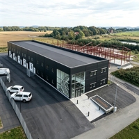 Atelier préfabriqué en structure métallique avec bureau, composants et plans de chantier