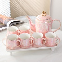 Elegante tetera de cerámica y 6 tazas de té con un mango de color dorado y una tapa con un acabado brillante iridiscente