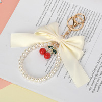 Porte-clés créatif polyvalent avec nœud papillon et petites perles, pendentif pour sac de téléphone portable pour femme