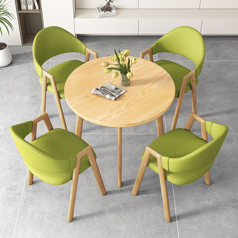 Une table et quatre chaises en couleur bois (chaises en tissu vert)