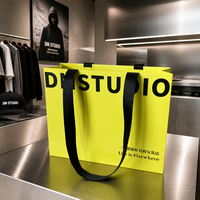 Sac shopping en papier jaune personnalisé avec poignée en ruban noir et logo pour la promotion de magasins de vêtements féminins, emballage en gros