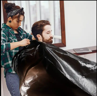 Capas de salón de plástico baratas PE corte de pelo bata de peluquería capa desechable de peluquero negro