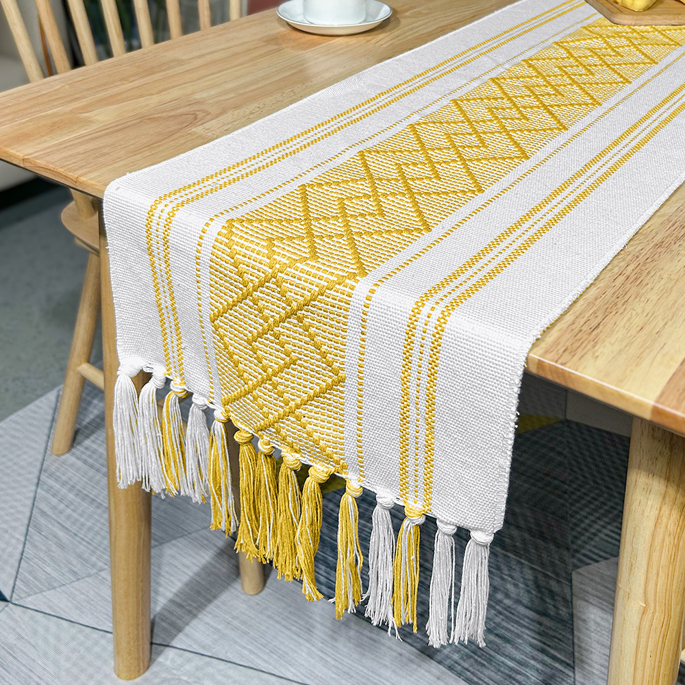 Runner da tavolo giallo dorato con nappe incrociate a forma di diamante