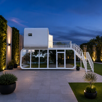 Maison préfabriquée modulaire de luxe à deux étages, type « Apple Cabin », avec terrasse et escalier, pour usage en hôtel, villa ou maison d'hôtes en station balnéaire