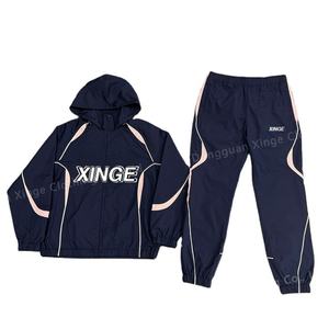 Ensemble sportif deux pièces personnalisé pour homme en polyester, comprenant une veste zippée en nylon et un pantalon de jogging patchwork avec techniques de broderie - Product Image 1