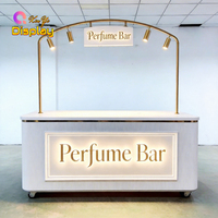 Comptoir de bar à parfums moderne de luxe avec éclairage LED personnalisé, panneau cannelé blanc, cadre doré pour les magasins de cosmétiques et les centres commerciaux