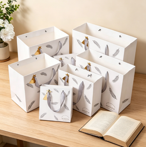 Sac en papier cadeau portable tendance, sac fourre-tout en papier blanc imprimé plumes argentées en gros pour l'emballage de cosmétiques et de bijoux de vacances - Product Image 4