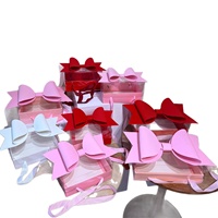 Boîte d'emballage en papier avec grand nœud rouge, blanc, rose et bleu, avec couvercle transparent