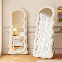 Miroir sur pied pleine longueur moderne en forme de vague irrégulière avec cadre en bois et peluche douce, idéal pour chambre à coucher, dressing et mode.